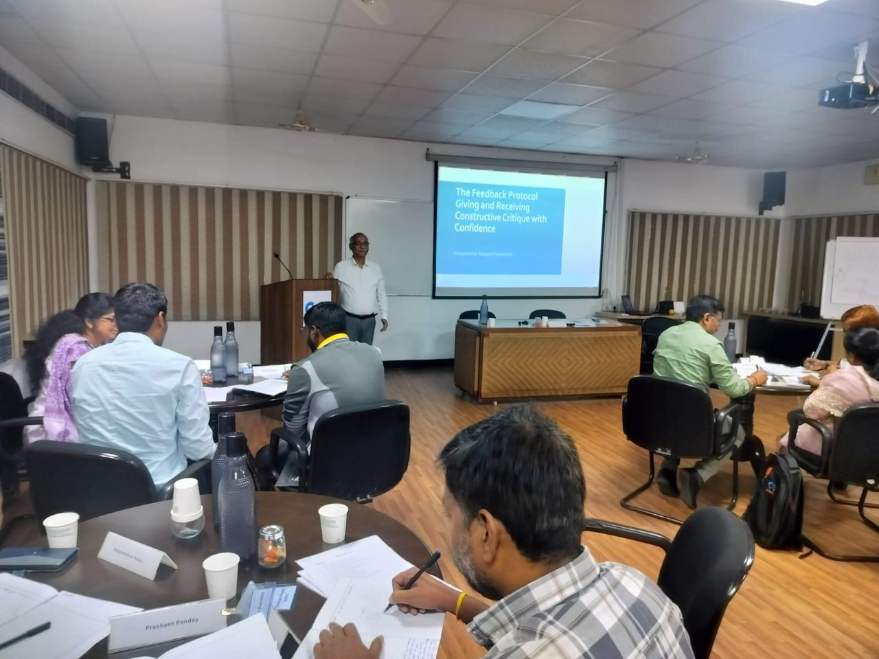 Participants practising the feedback protocol at their tables during a Gaucr workshop